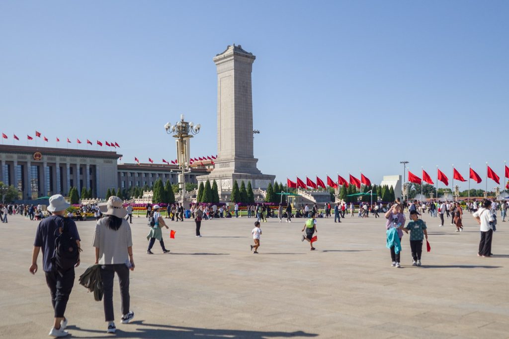 a group of people walking around a large building